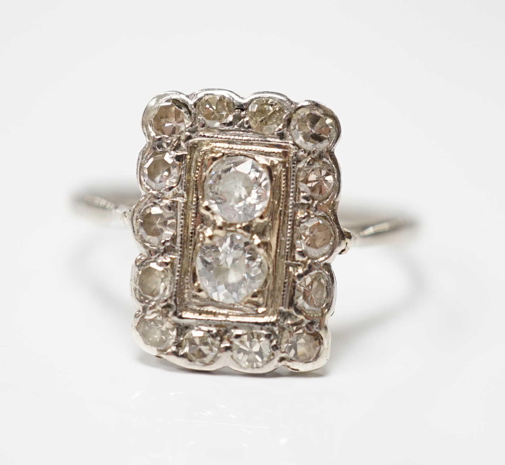 An early 20th century white metal and diamond cluster set tablet ring, size P/Q, gross weight 2.2 grams.